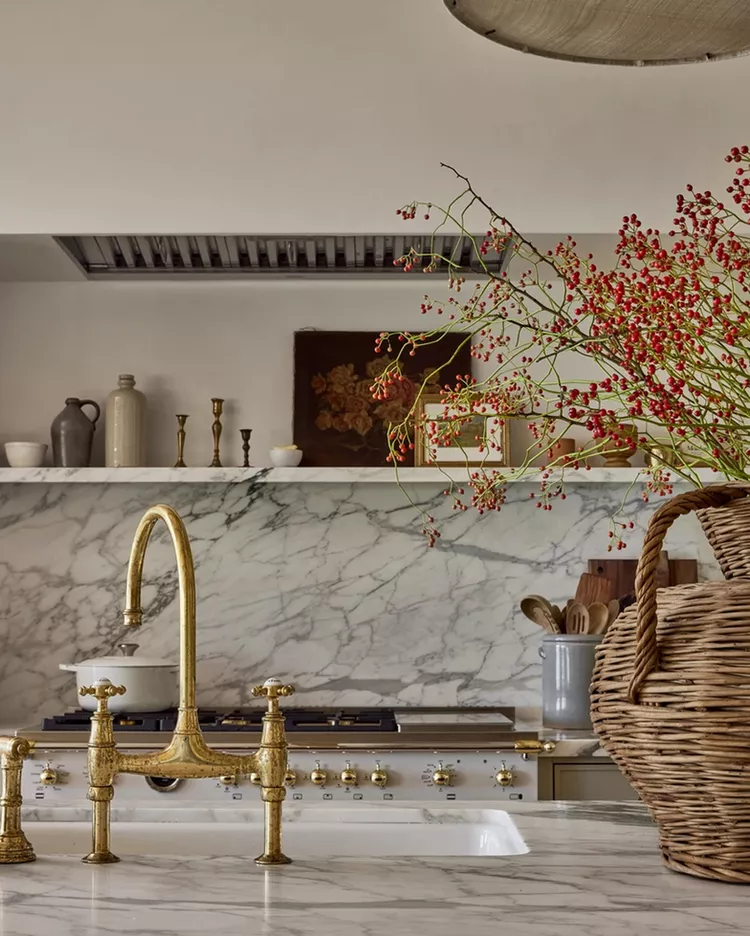 Кухня с мраморной столешницей и золотым смесителем