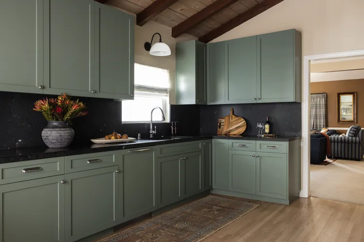 Кухня с зелеными фасадами и черным фартуком