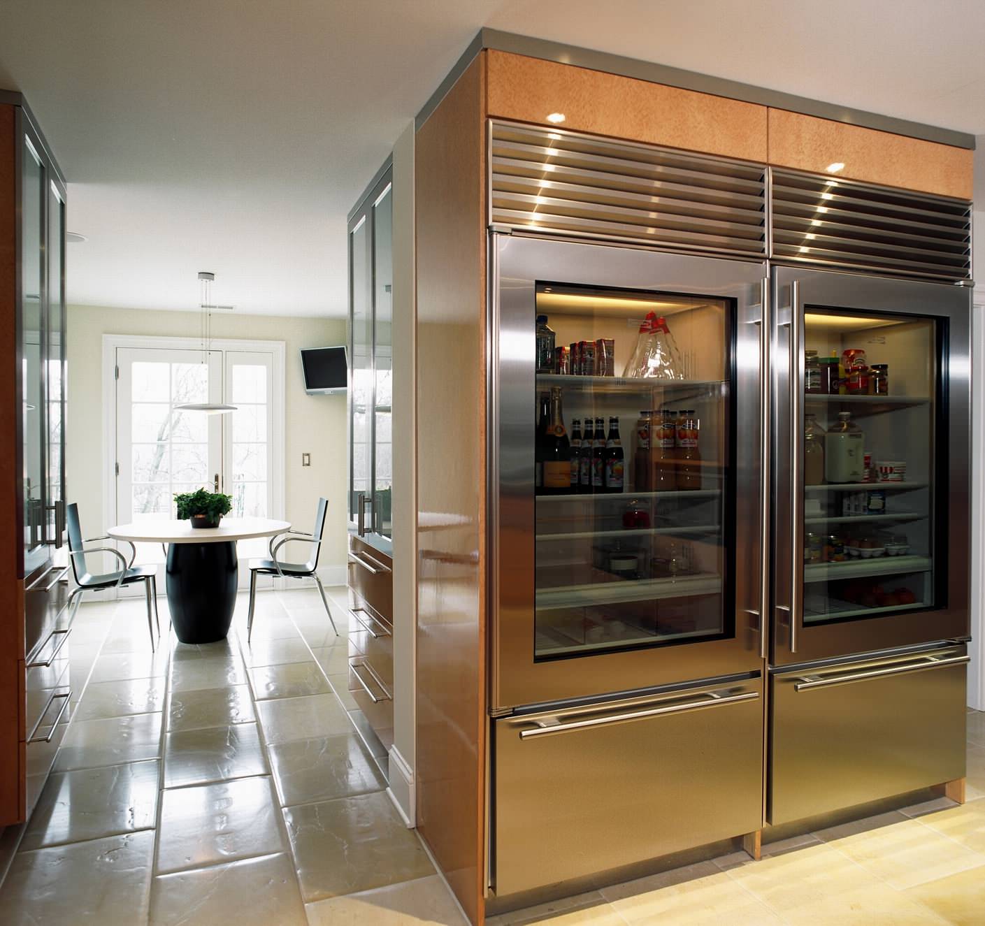 Стеклянные дверцы металлического холодильника на кухне