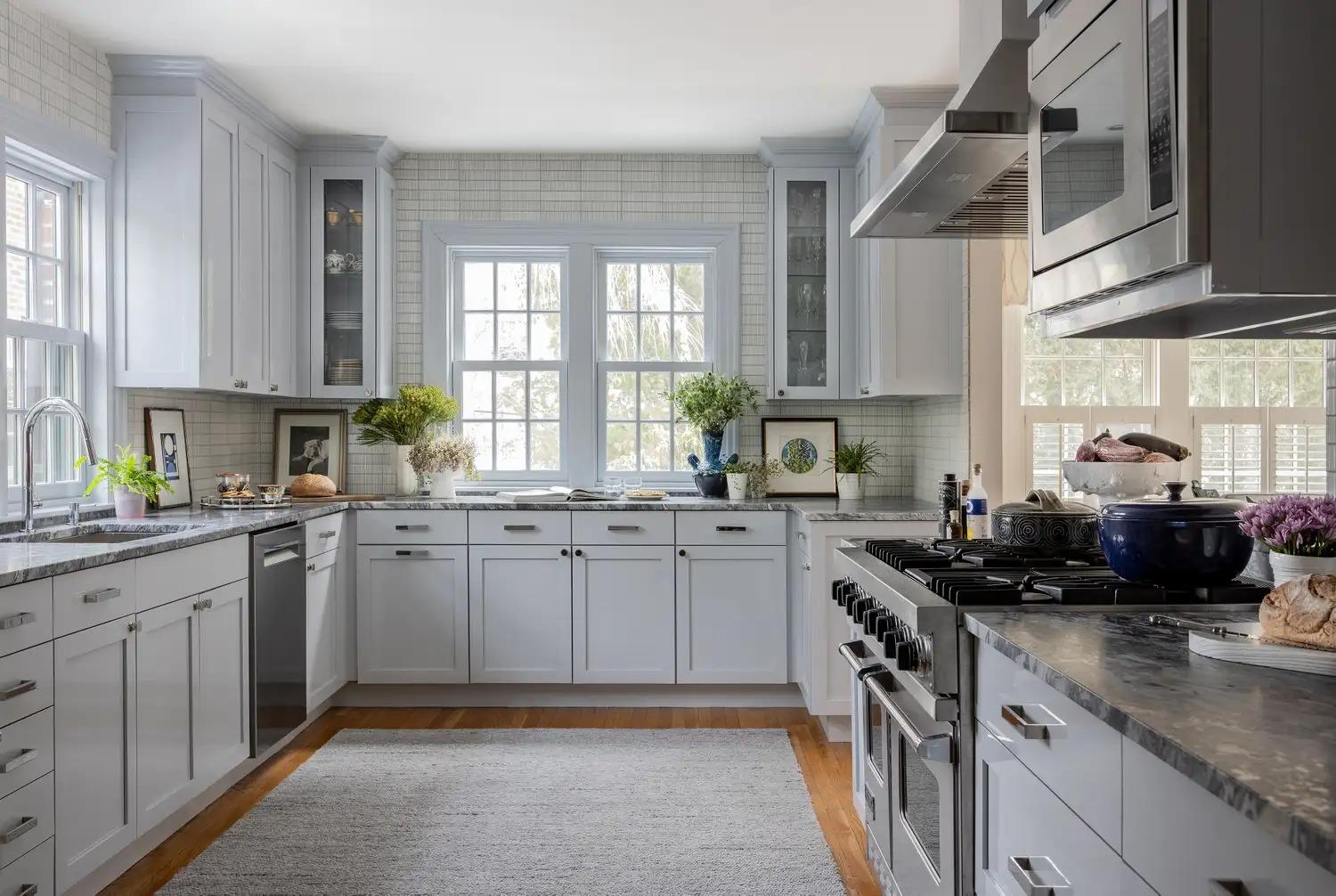 Светлая кухня с белыми шкафами и большой плитой