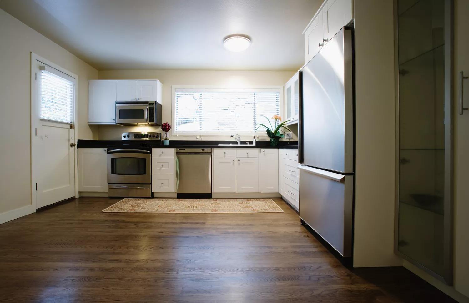 Светлая кухня с потолочным освещением и деревянным полом