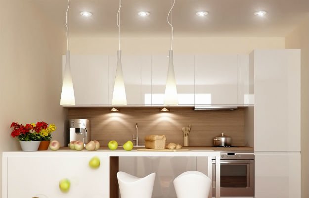 Конусообразные подвесные светильники на длинных шнурах в интерьере белой кухни