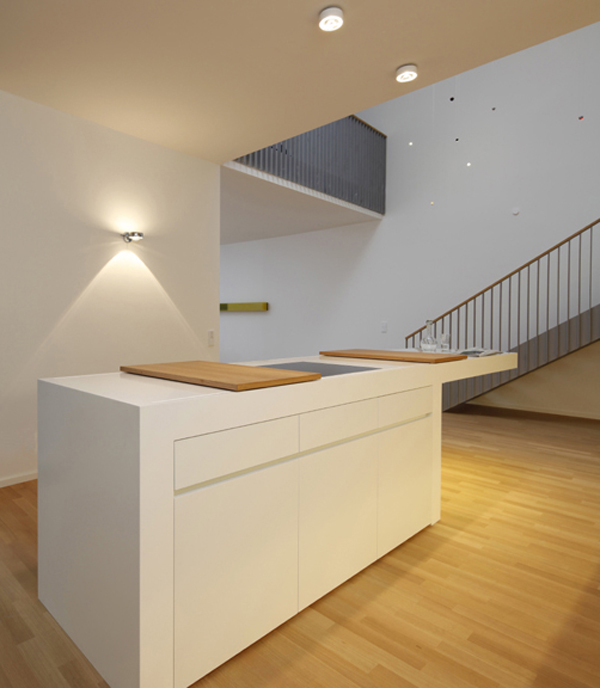 Дизайн на кухне под лестницей: деревянные доски на стойке из кориана