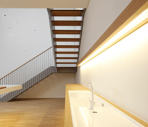 Дизайн кухни под лестницей: раковина с белым краном