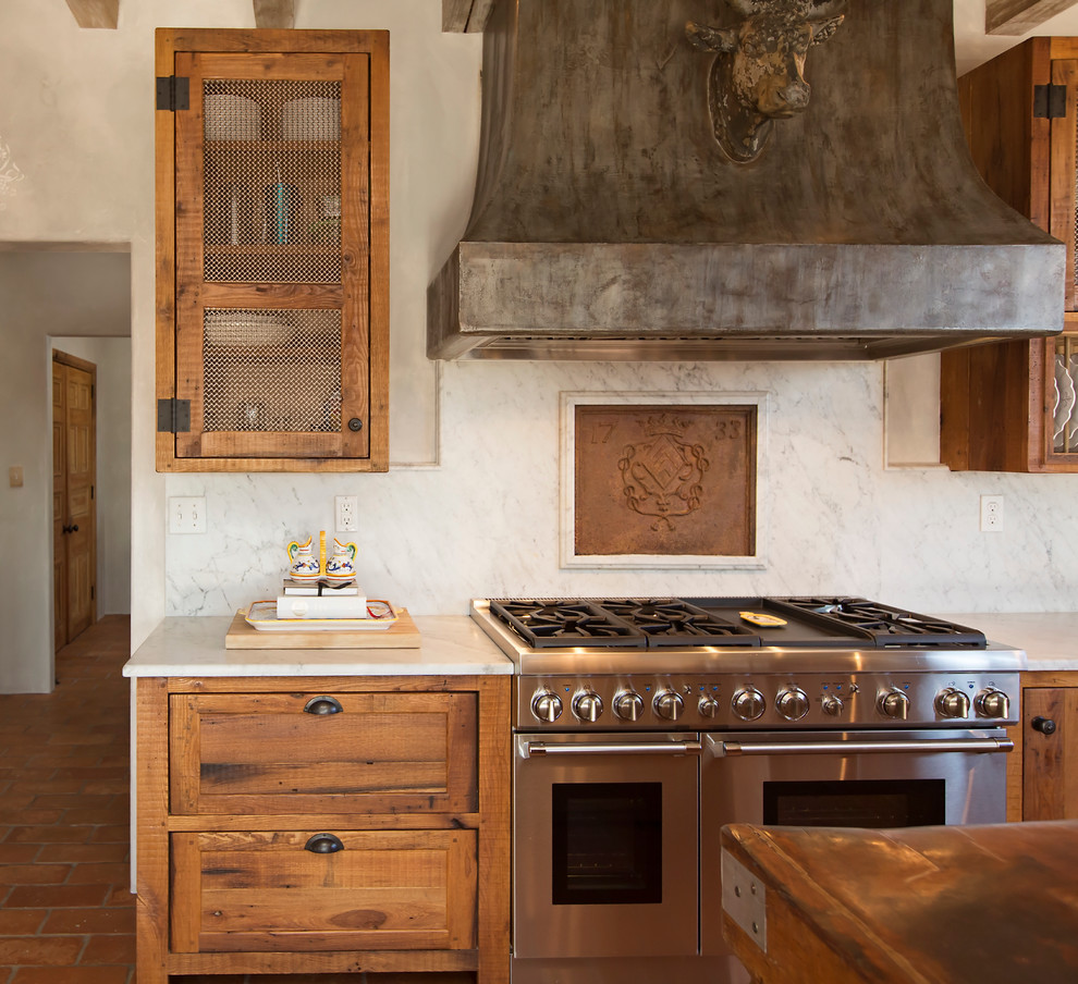 Дизайн кухни в деревенском стиле: фамильный герб над плитой