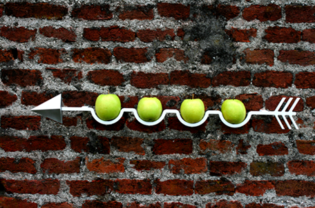 Креативная настенная подставка для фруктов и овощей в виде стрелы с зелёными яблоками в ячейках