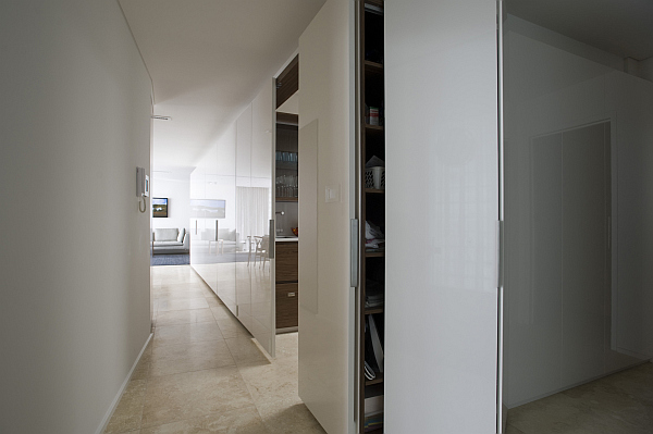 Белый глянцевый шкаф с подсветкой в коридоре и раздвижными дверцами