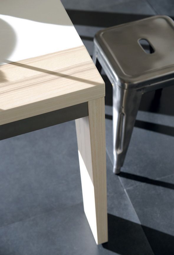 Детали интерьера: деревянный угол стола и металлический табурет в интерьере кухни