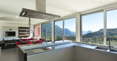 Интерьер просторной кухни стального цвета с красивым видом из окна