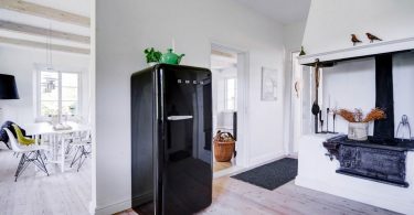 Отдельно стоящий черный холодильник в интерьере