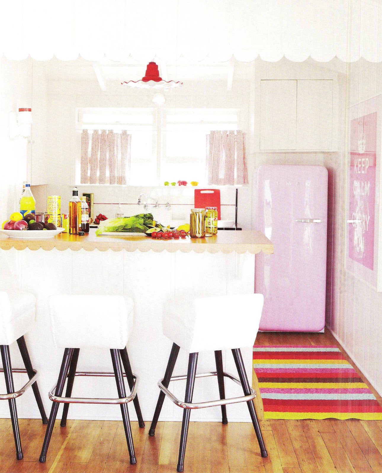 Розовый холодильник SMEG в интерьере белоснежной кухни