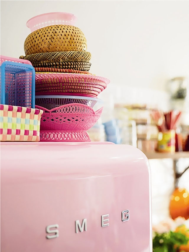 Разноцветные пластиковые корзинки на розовом холодильнике SMEG 