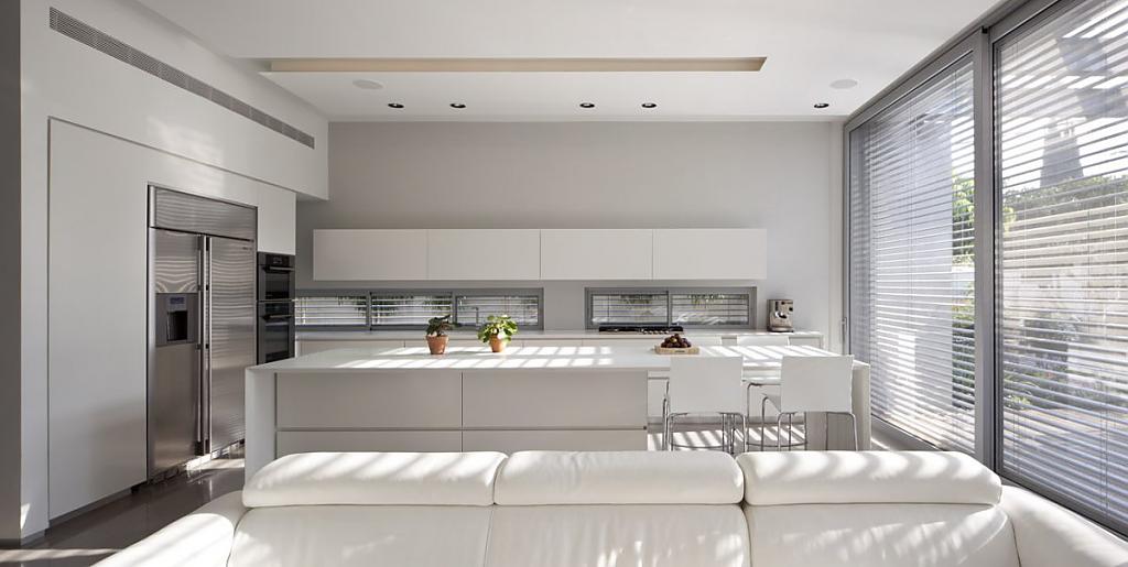 Элегантный дизайн белой кухни с большими мягкими диванами