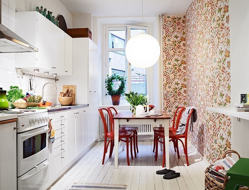 Яркие цветочные принты  в оформлении стены белой кухни 